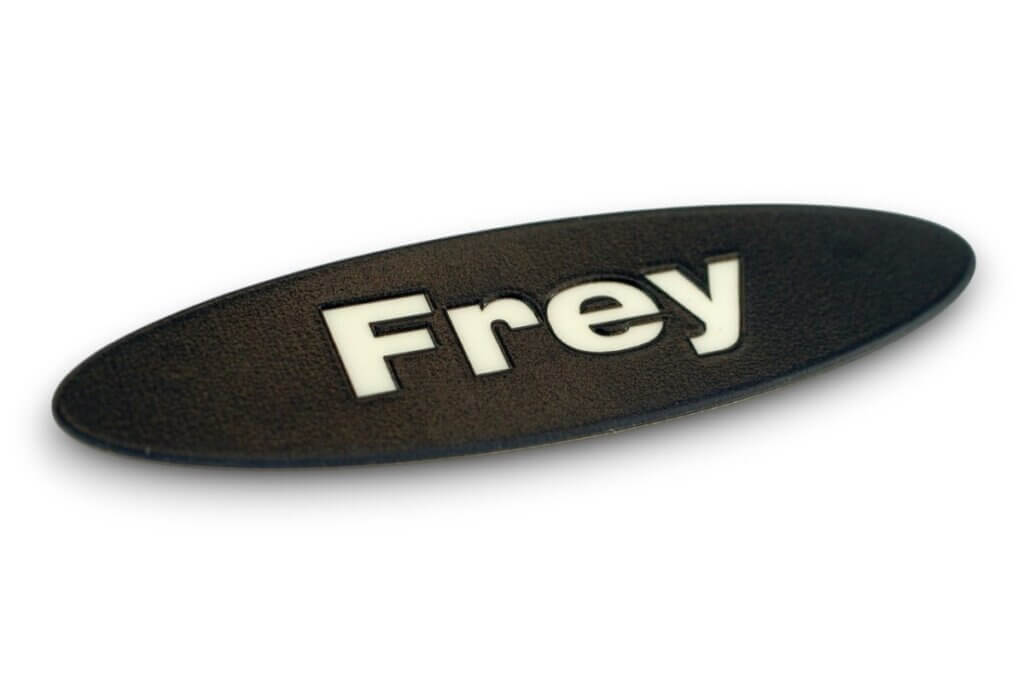 Oval black product plate with the Frey brand logo