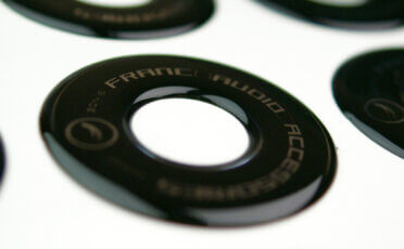 Black round convex sticker with a cutout of the Franc Audio Accessories logo